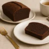 Cake au chocolat sans gluten au Thermomix : tranche moelleuse à la poudre d’amandes, vue en biais sur table en bois.