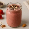 Smoothie Fraise–Chocolat–Amande au Thermomix, garni d’amandes et d’éclats de cacao.